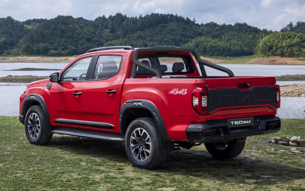 Roter Pickup-Truck Maxus T60 MAX am Ufer eines Gewässers, umgeben von grüner Landschaft.