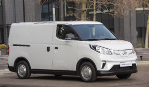 Weißer Lieferwagen parkt auf einer modernen Straßenoberfläche, im Hintergrund moderne Gebäude.